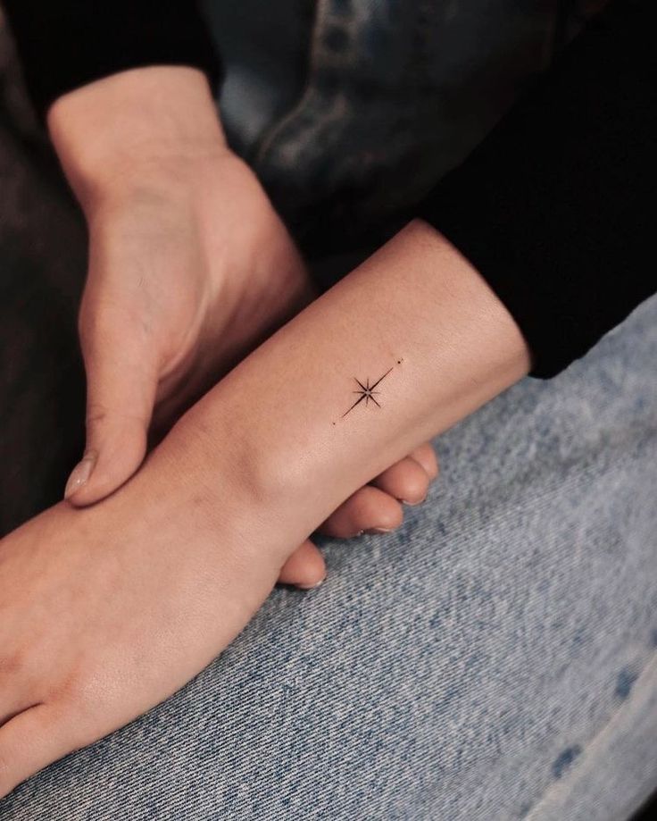 a person with a small star tattoo on their arm