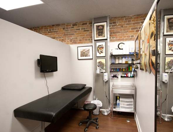 a room with a desk, shelves and pictures on the wall