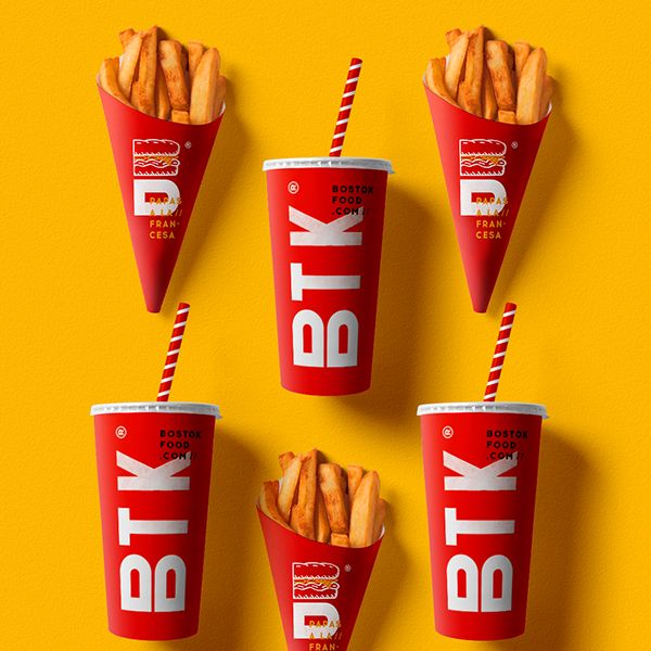 four red cups filled with french fries on top of a yellow background