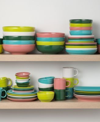 the shelves are full of colorful dishes and cups on them, all stacked up in different colors