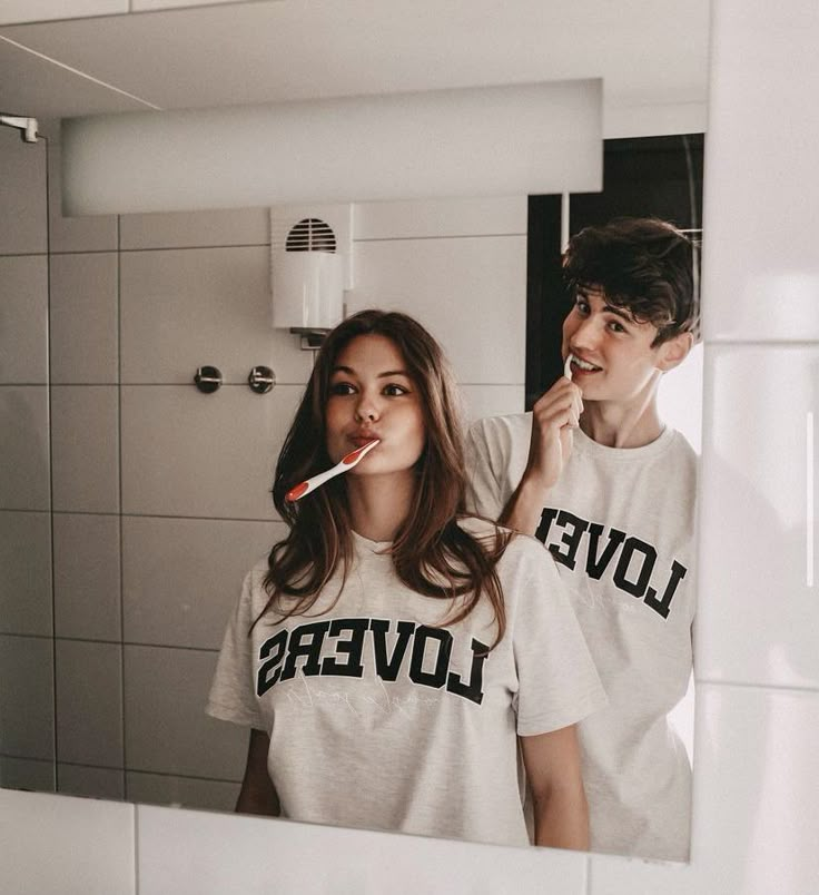 a woman brushing her teeth in front of a mirror with the words love lovers on it