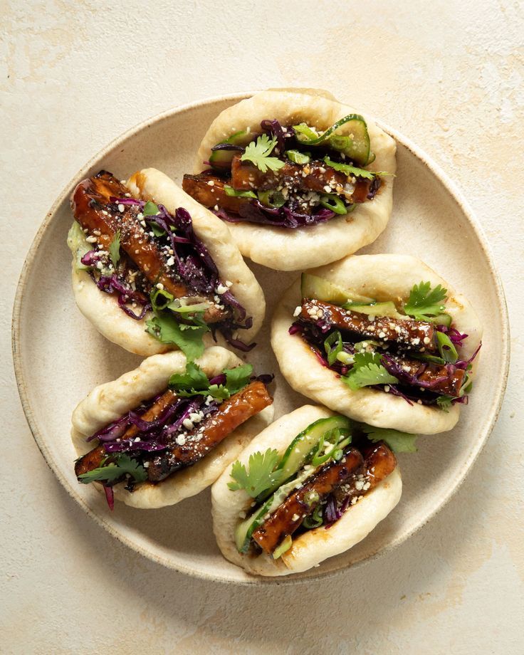 small pita sandwiches with meat, lettuce and sauce on them in a bowl