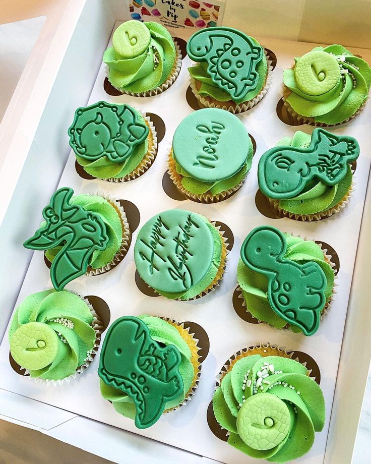 cupcakes decorated with green frosting in a box