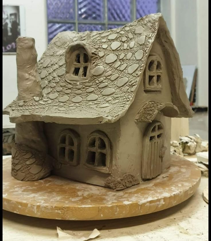 a clay house sitting on top of a table