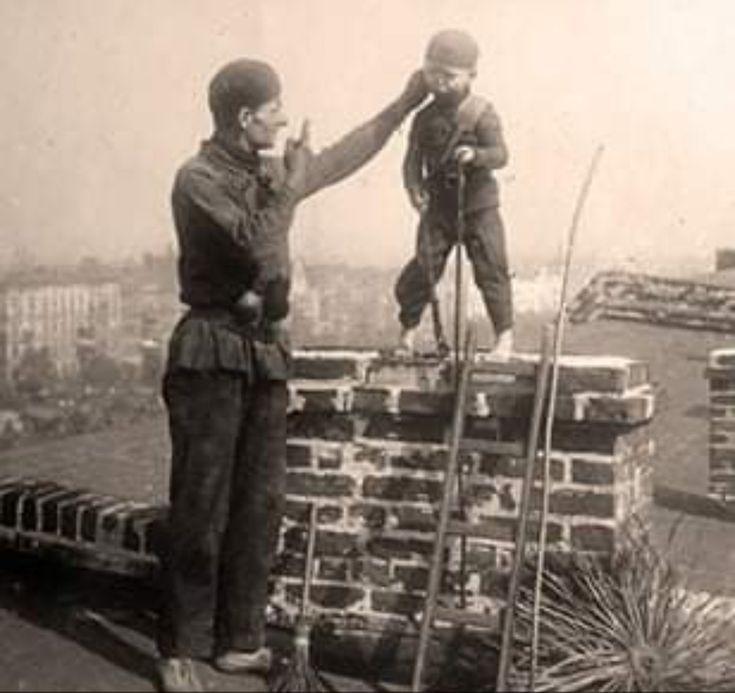 two men standing on top of a brick wall