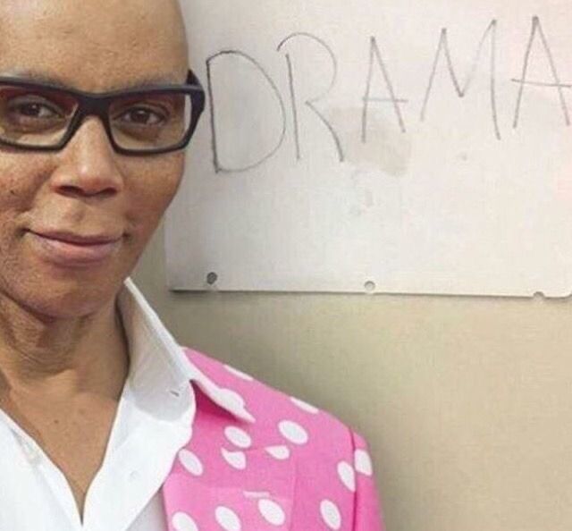 a bald man wearing glasses standing in front of a white board with writing on it