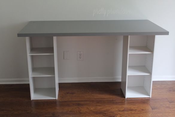 a white desk with shelves on top of it in an empty room next to a wall