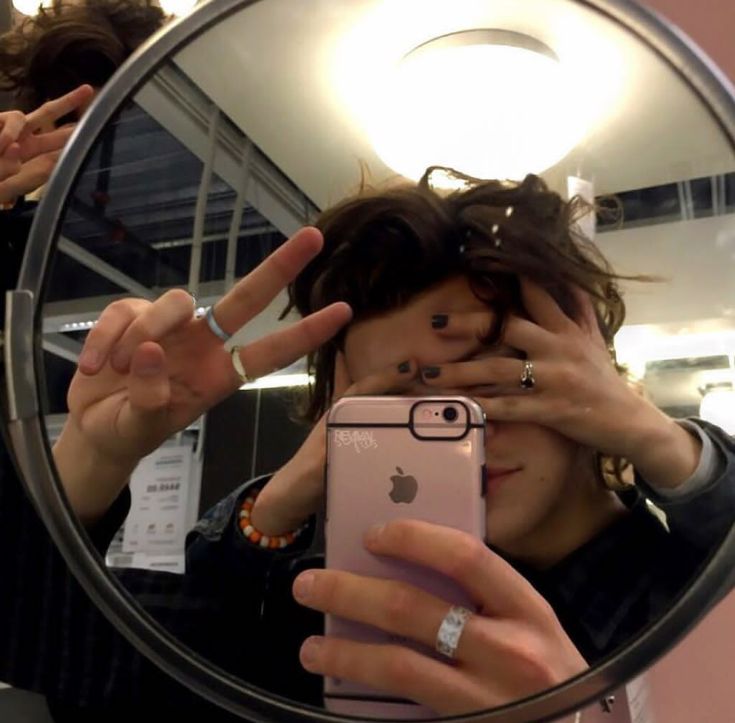 a woman taking a selfie in front of a mirror with her fingers up to the camera