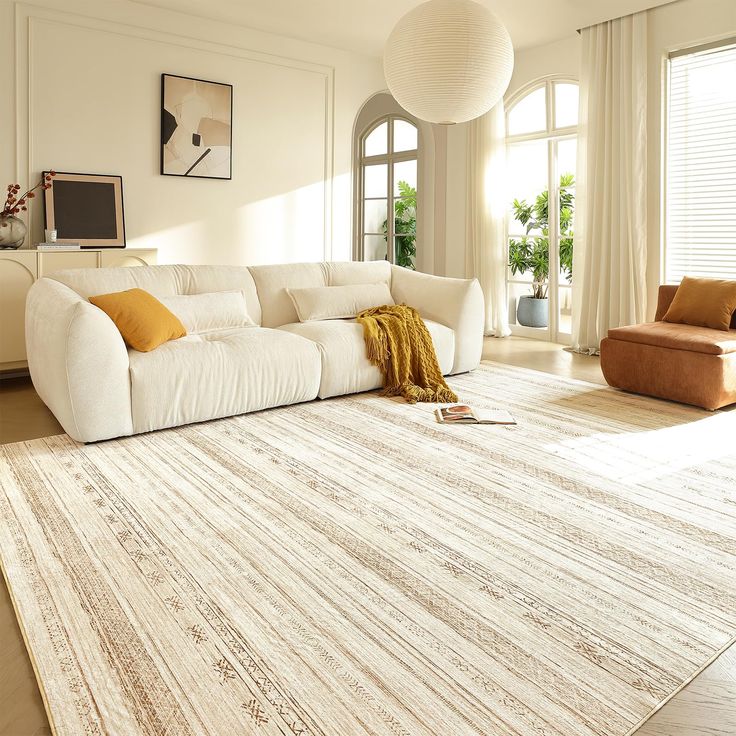 a large white couch sitting on top of a rug in a living room