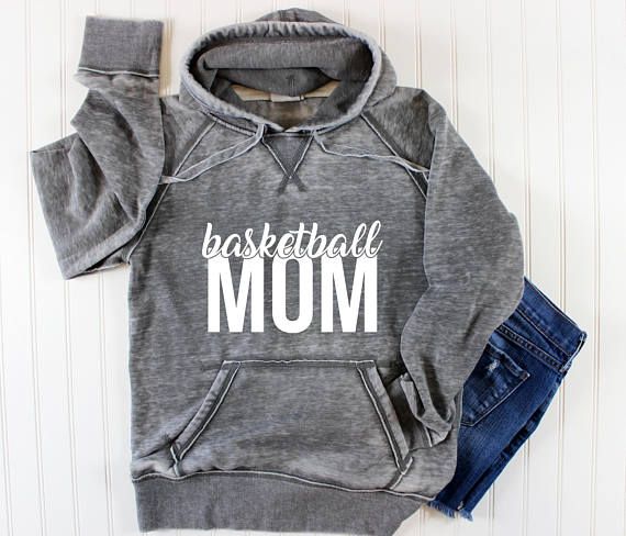 a sweatshirt with the word football mom on it and jeans next to it, sitting on a white background