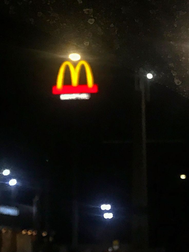 a mcdonald's sign is lit up at night