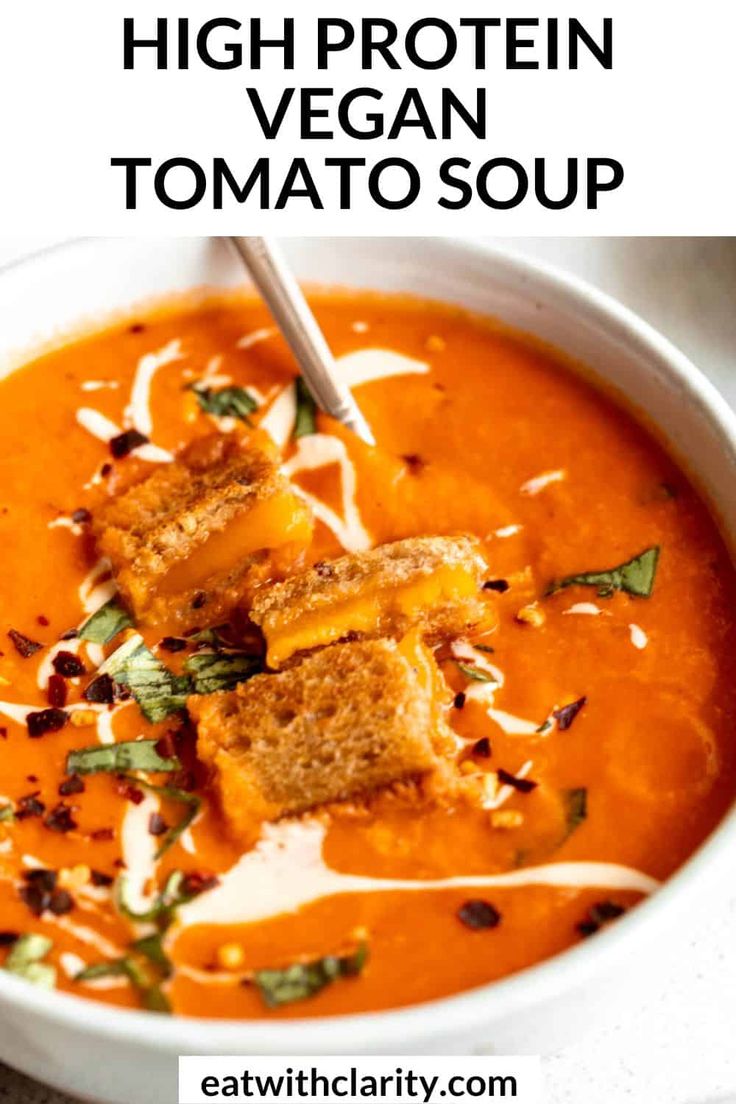 a white bowl filled with tomato soup and tofu croutons on the side