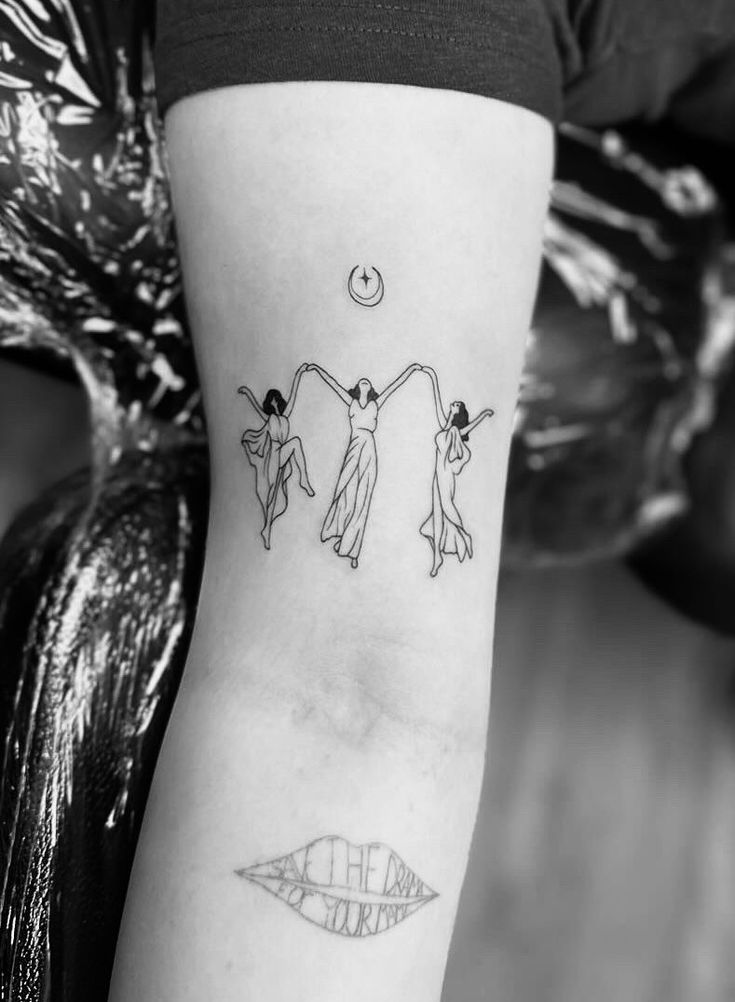 a woman's arm with two women holding hands and the moon above her head