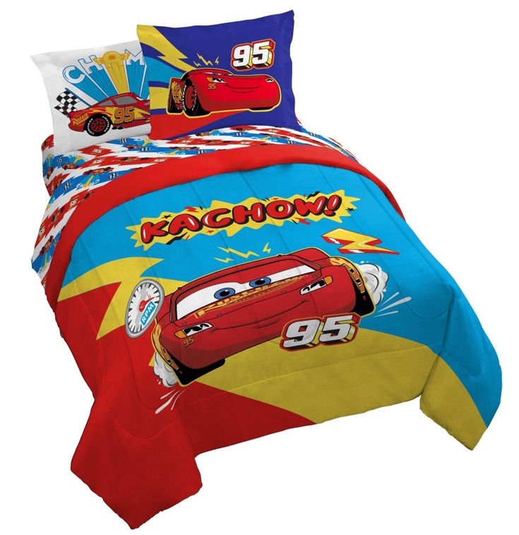 a bed with cars comforter and pillows on top of it, in front of a white background