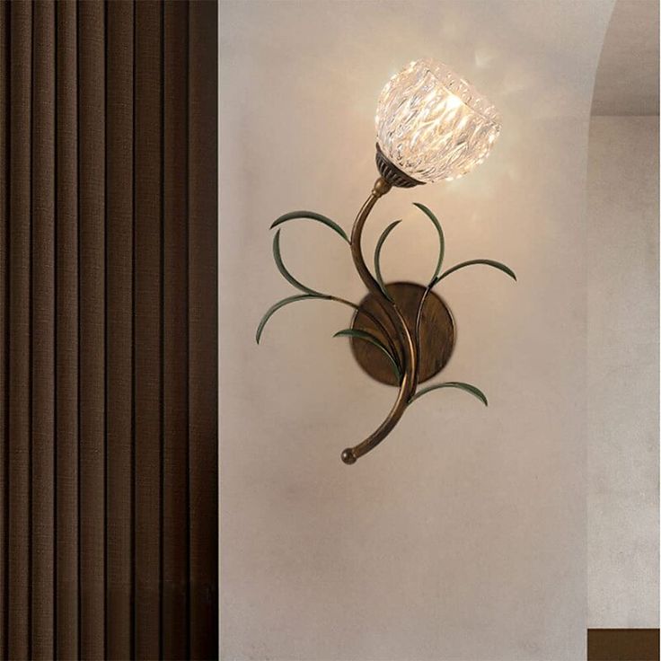 a wall light with a glass flower on it