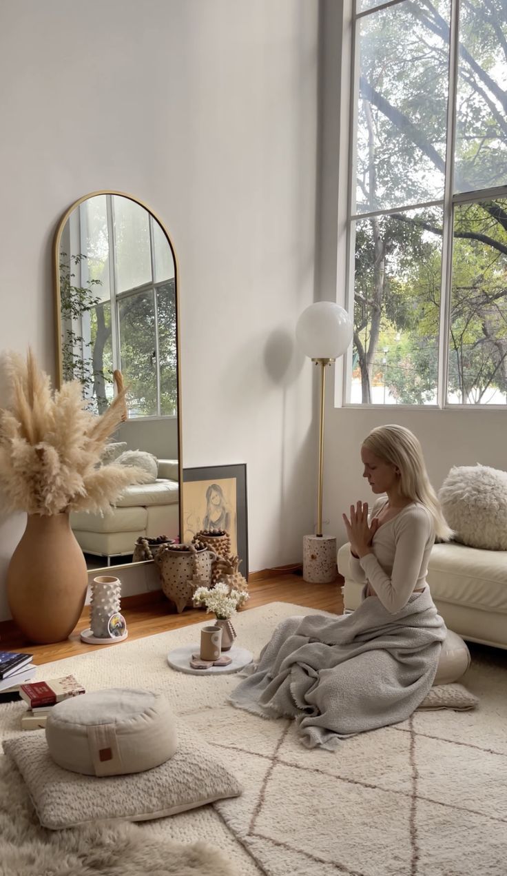 a woman sitting on the floor in front of a mirror