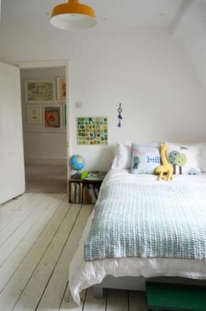 a bedroom with white walls and wooden floors