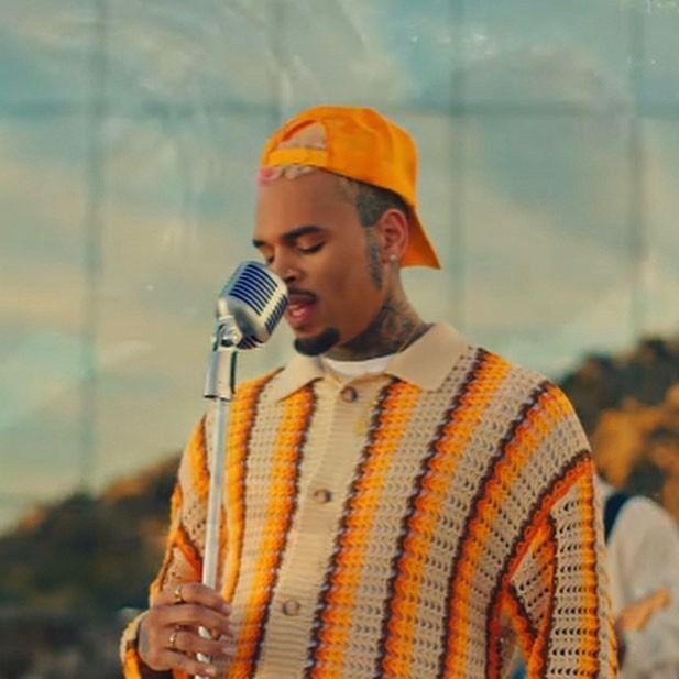 a man in an orange and white sweater holding a microphone