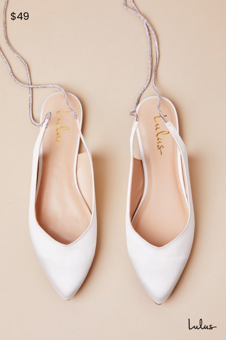 a pair of white shoes hanging from a string on top of a beige background with the price $ 495