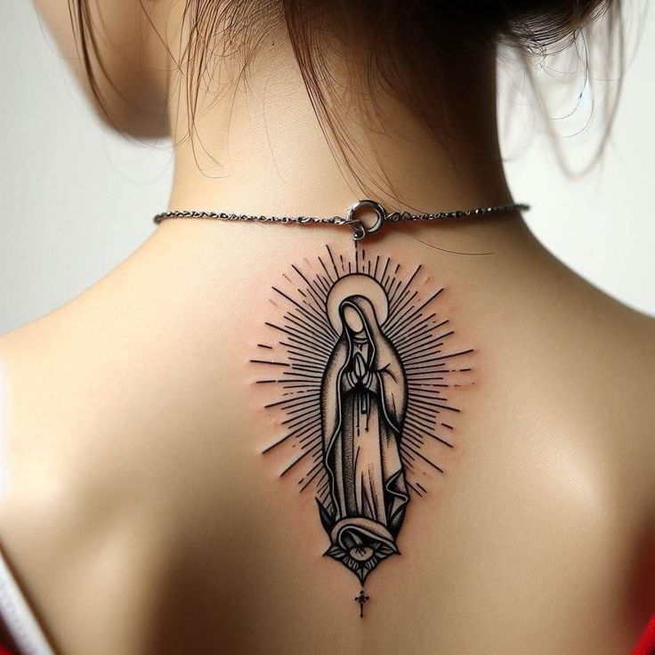 the back of a woman's neck is adorned with a tattoo of the virgin mary