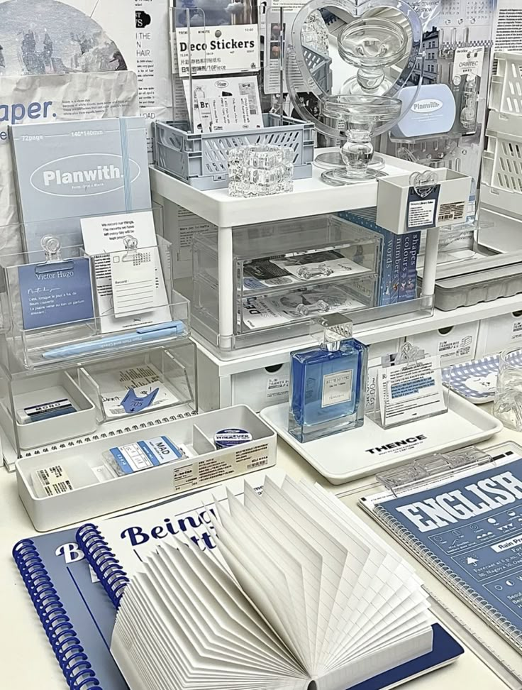 an assortment of office supplies on display in a store window, including notebooks and pens