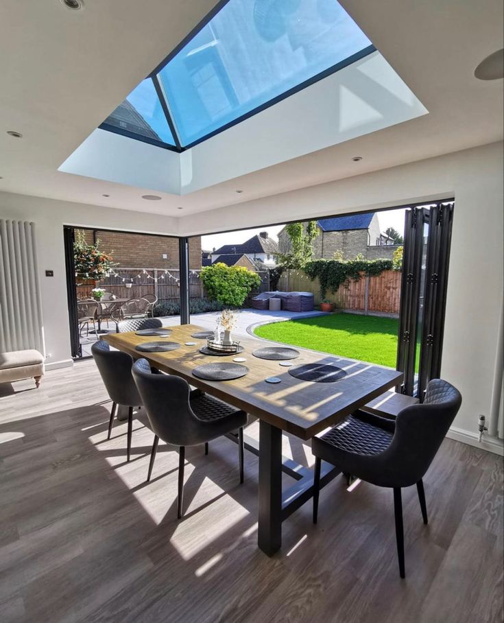 a dining room table with chairs and a skylight