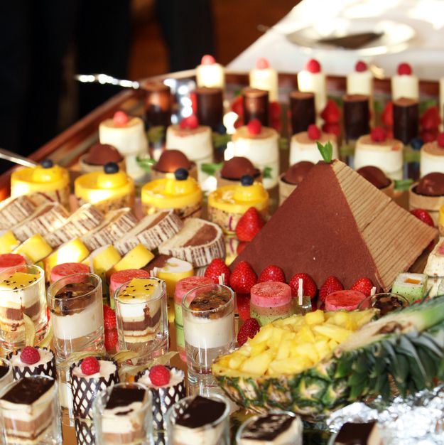 an assortment of desserts are arranged on a buffet table, including pineapples and strawberries