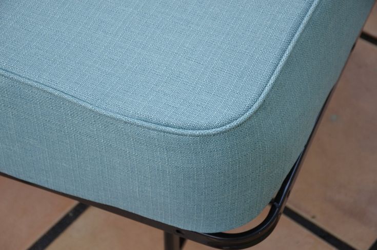 a blue chair sitting on top of a tiled floor