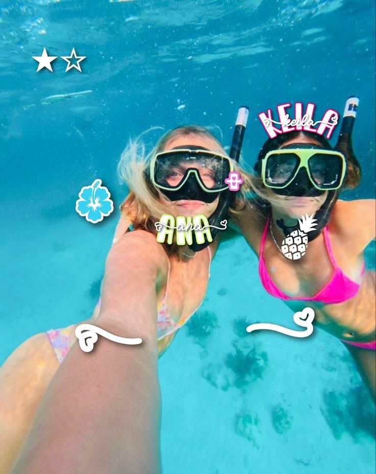 two women wearing masks and snorkels in the water