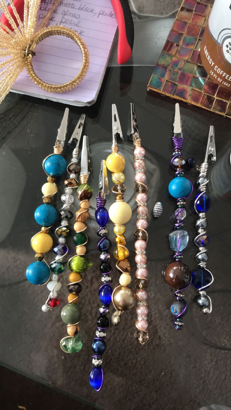 a table topped with lots of different types of beads and earrings on top of it