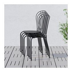 three black chairs sitting on top of a tiled floor next to a potted plant