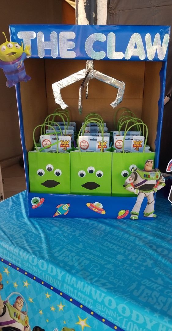 the claw display is set up on top of a blue table cloth with toy figures