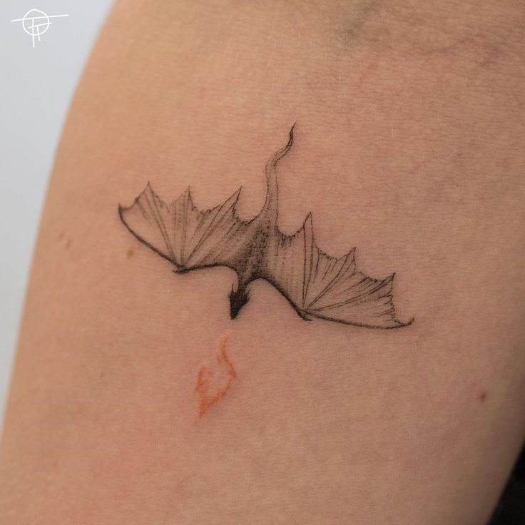 a black and white photo of a leaf on the back of a woman's shoulder