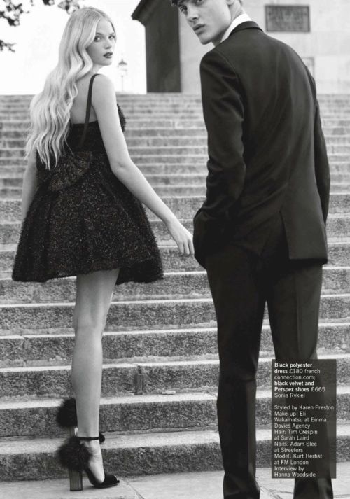 a young man and woman are standing on the steps holding hands, looking at each other