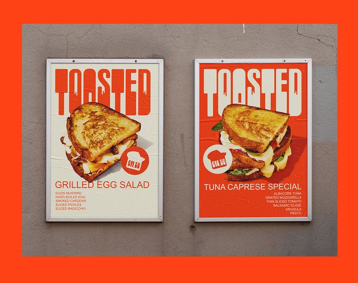 two posters on the side of a building advertising toasted sandwiches