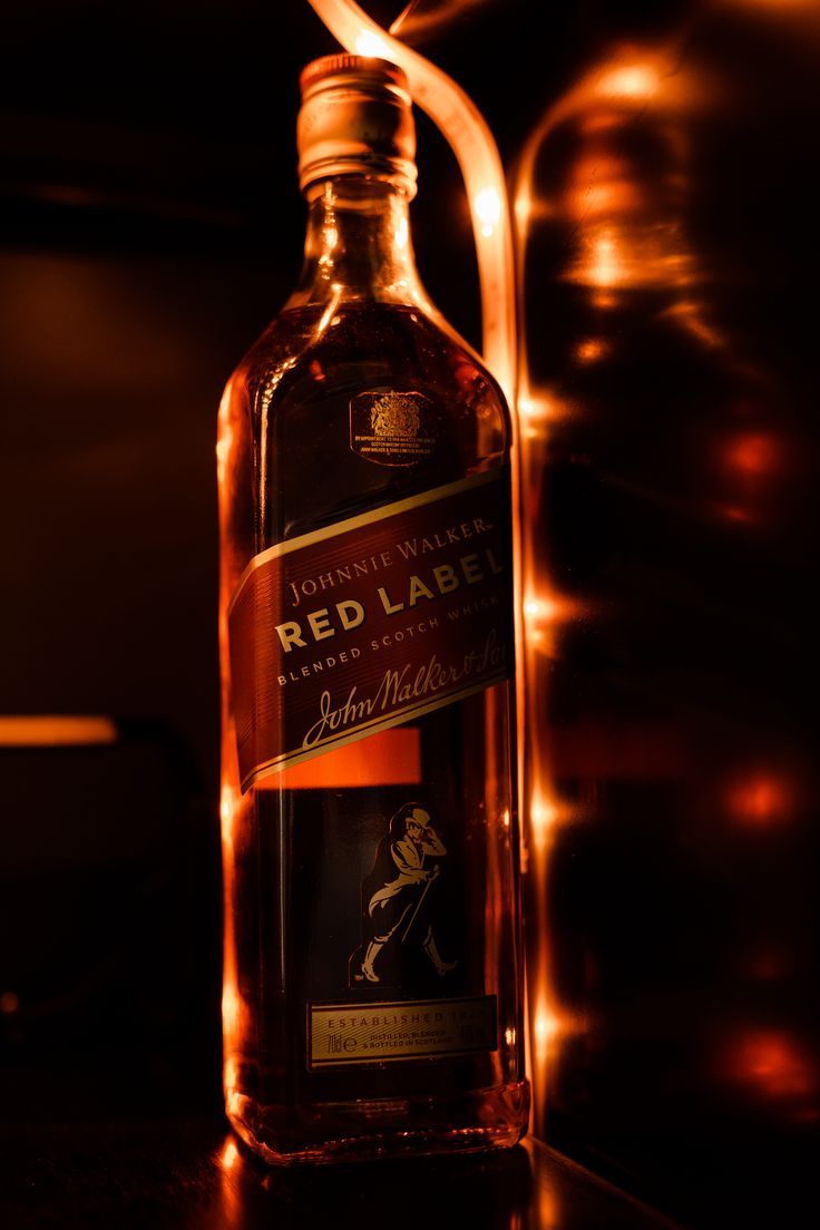 a bottle of red label whisky sitting on top of a table