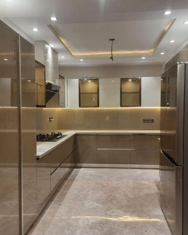 an empty kitchen with stainless steel appliances and counter tops in the middle of the room