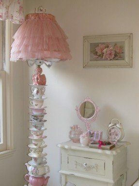 a room with a lamp, dresser and other items on the table in front of it