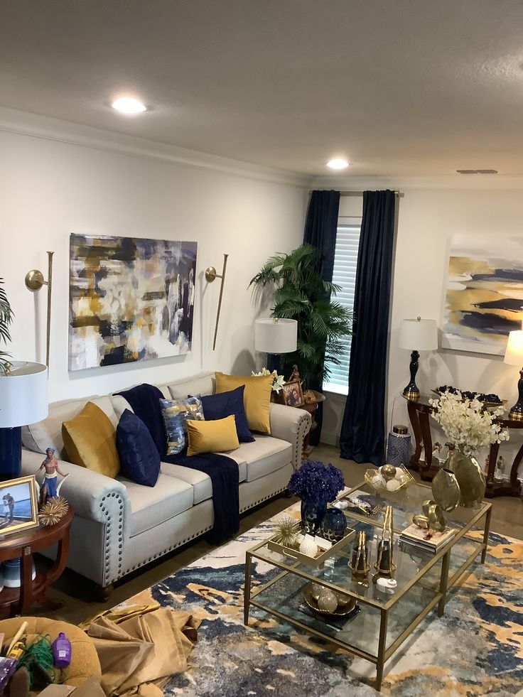 a living room filled with lots of furniture next to a large painting on the wall