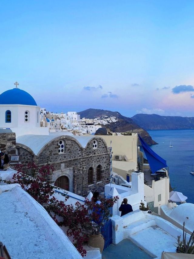 a view of the ocean and buildings in oia