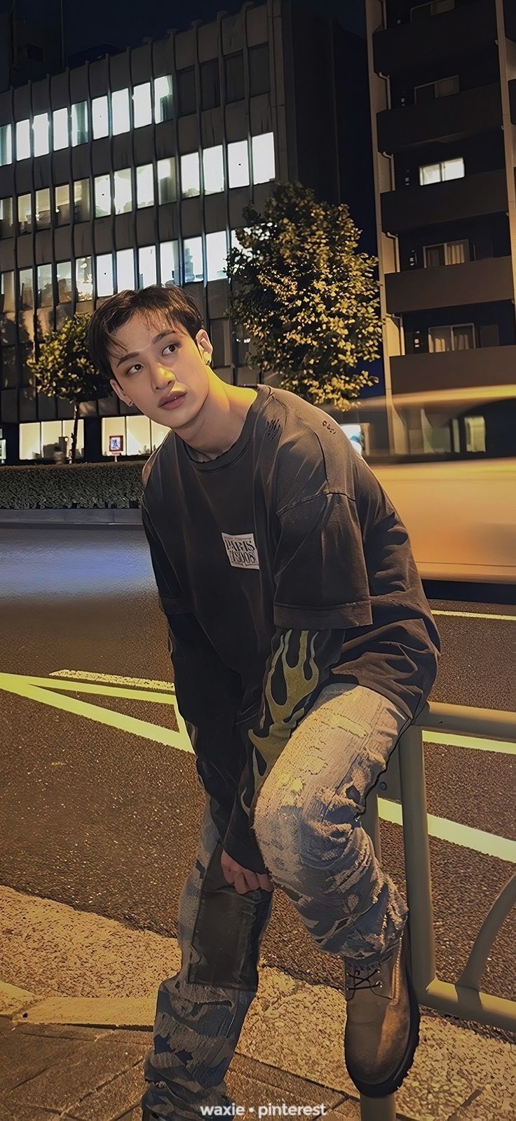 a young man riding a skateboard on top of a metal rail next to a street