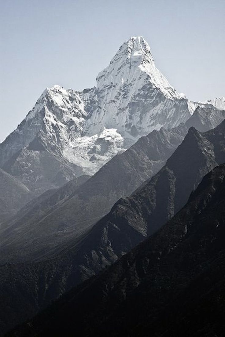 a snow covered mountain with trees in the foreground