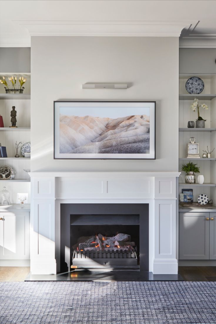 a living room filled with furniture and a fire place in front of a painting on the wall