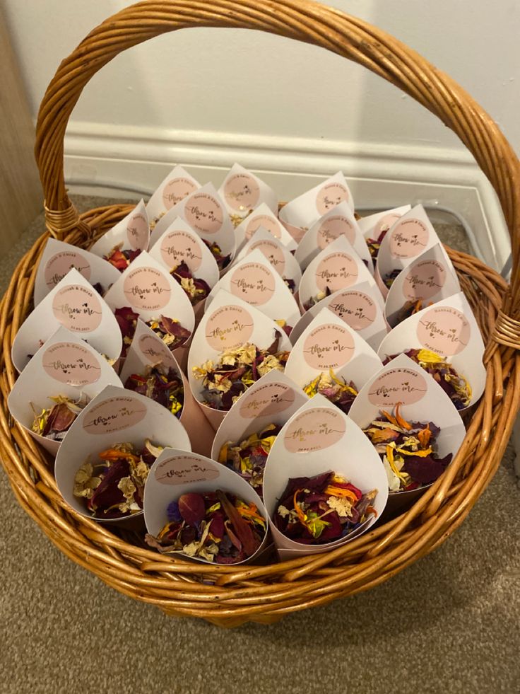 a wicker basket filled with lots of different types of dried flowers in small tags