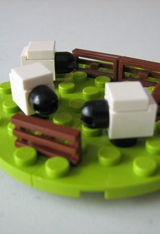 there is a toy train set on the green plate with black and white pieces in it