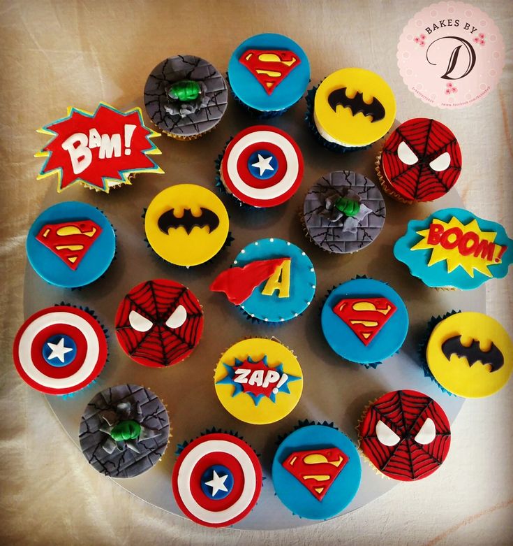 cupcakes decorated like superheros are arranged in a circle