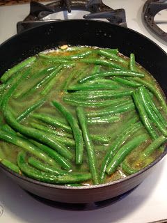 green beans are cooking in a skillet on the stove