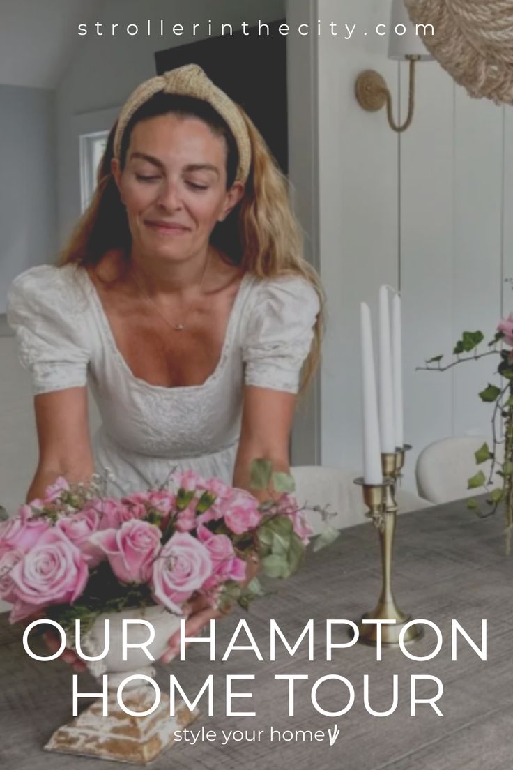 a woman sitting at a table with flowers in front of her and the words our hampton home tour