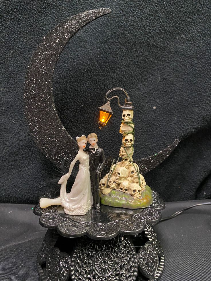 a wedding cake topper with a bride and groom standing on it's side