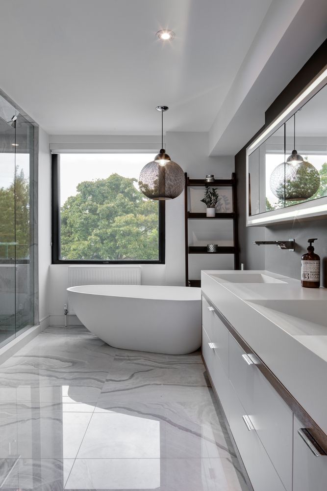 a bathroom with a large bathtub next to a walk in shower and two sinks